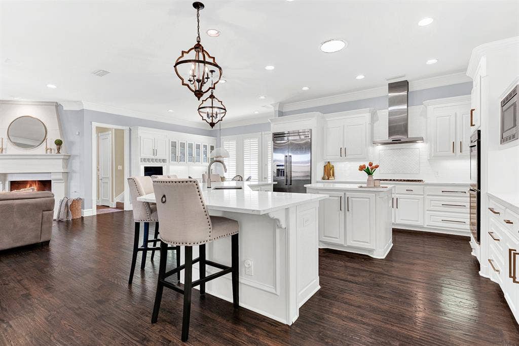2608 LAWTON Lane, Plano, TX 75093 Crisp white quartz countertops and pristine subway tile create an effortless bridge into the adjoined living space. Imagine sipping a hot cup of tea at the counter while listening to the cozy crackle of the family room fire