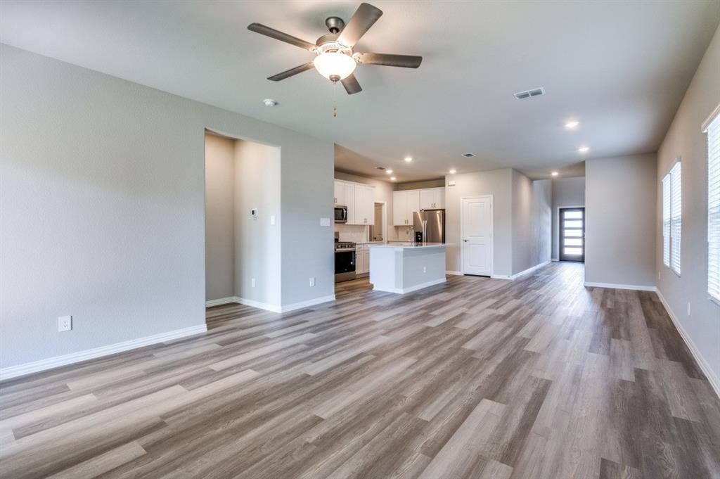 Open-concept interior featuring wood-finish flooring, recessed lighting, a ceiling fan, and a kitchen island with built-in cabinetry