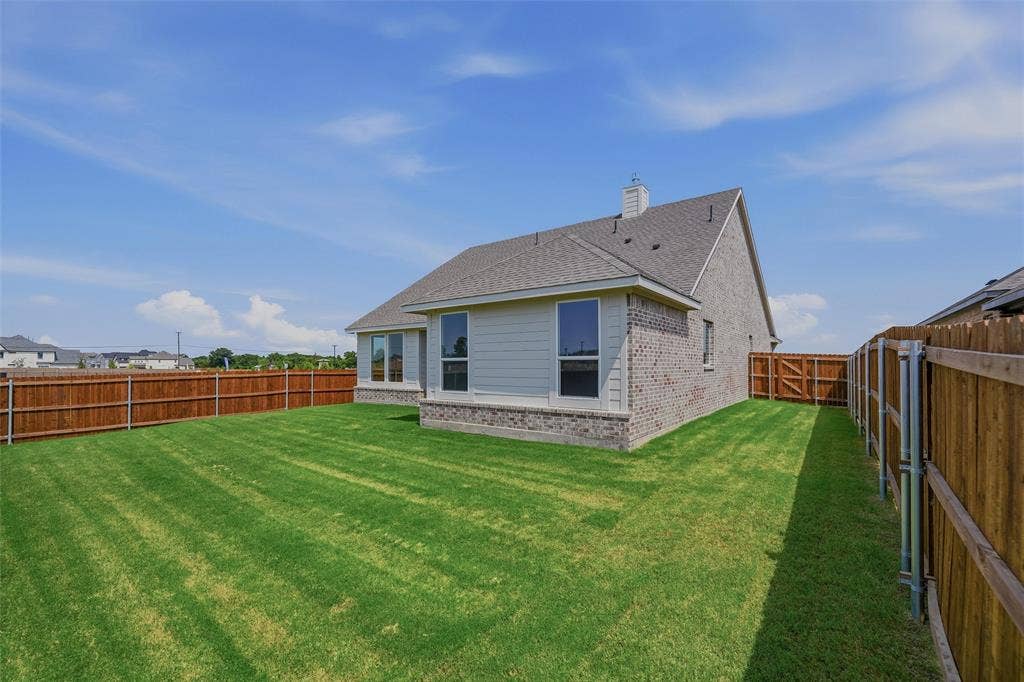 2109 Bluebird Lane, Anna, TX 75409 Expansive rear yard with a manicured lawn, full wood fencing, and a side gate