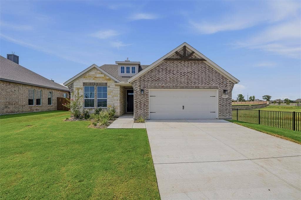 2109 Bluebird Lane, Anna, TX 75409 Brick and stone exterior featuring an attached garage, dormer window, and covered entry