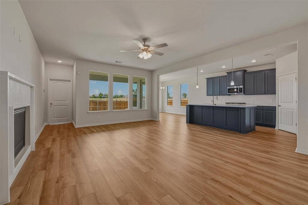 2109 Bluebird Lane, Anna, TX 75409 Expansive open-concept living area featuring wood-finish flooring, recessed lighting, and a ceiling fan