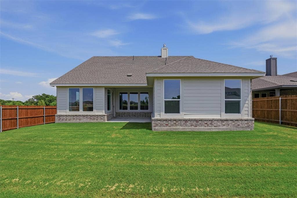2109 Bluebird Lane, Anna, TX 75409 Expansive backyard featuring a manicured lawn, wood fencing, and a covered patio