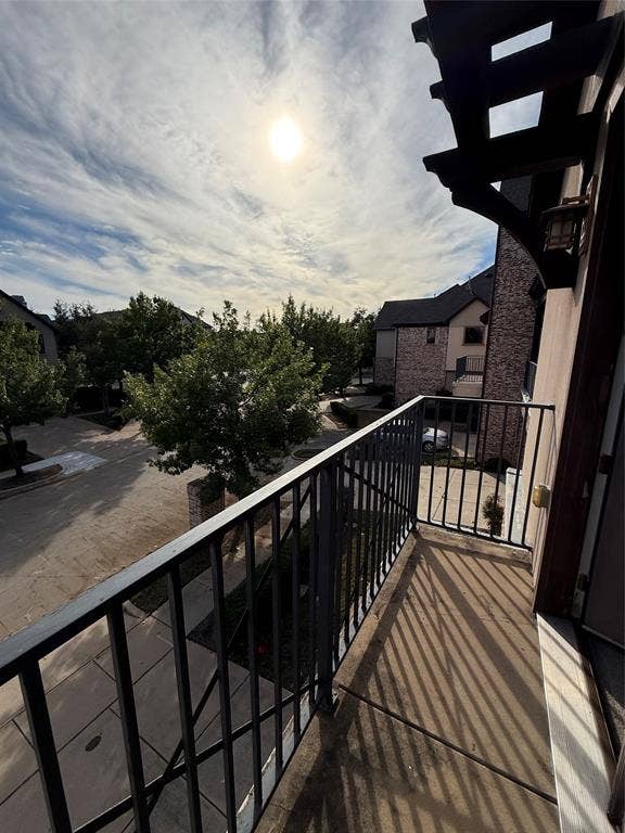 1025 Emerson Park Lane, Irving, TX 75063 Elevated balcony featuring a metal railing, concrete flooring, and an attached wall-mounted lantern