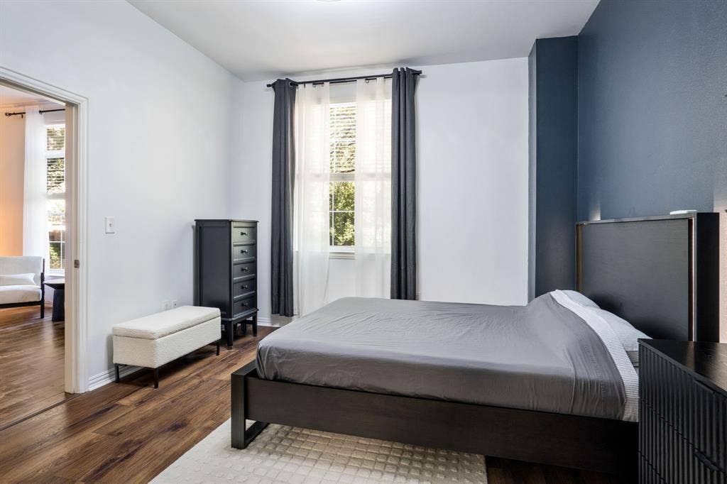 2305 Worthington Street, #103, Dallas, TX 75204 Wood-finish flooring, multi-pane window with grid detailing, and a charcoal accent wall