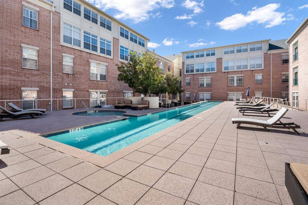 2305 Worthington Street, #103, Dallas, TX 75204 Outdoor pool area featuring a multi-level concrete deck, integrated spa, perimeter metal railings, and mature trees