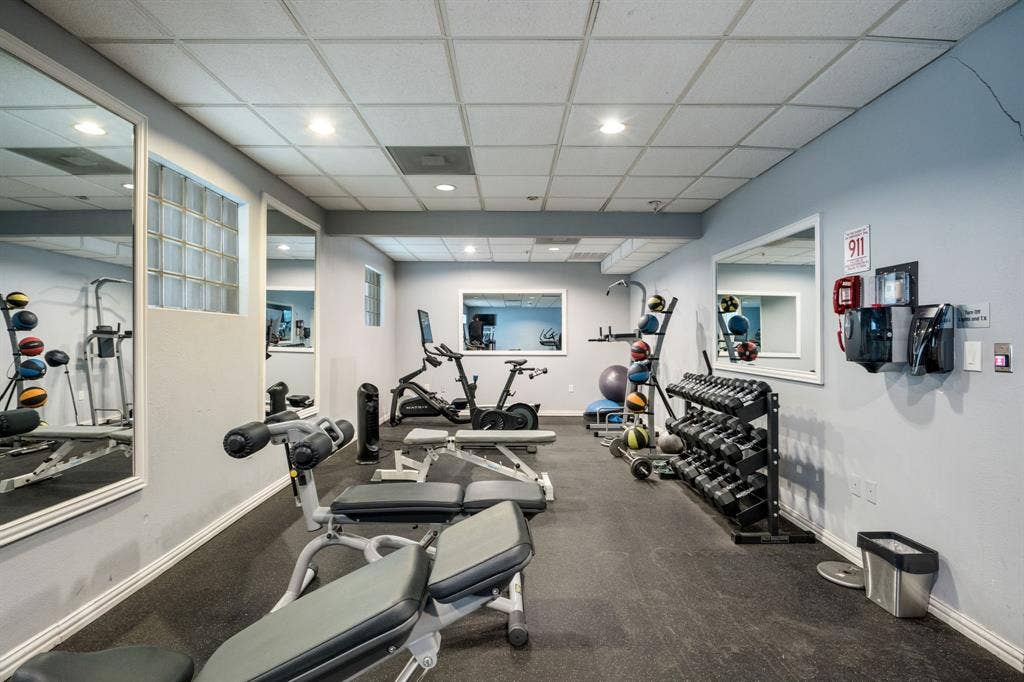 2305 Worthington Street, #103, Dallas, TX 75204 Fitness area featuring wall-to-wall mirrors, recessed lighting, drop ceiling, glass block accent windows, and rubberized flooring