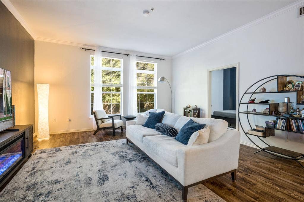 2305 Worthington Street, #103, Dallas, TX 75204 Living area featuring wood-finish flooring, high ceilings with crown molding, and tall windows