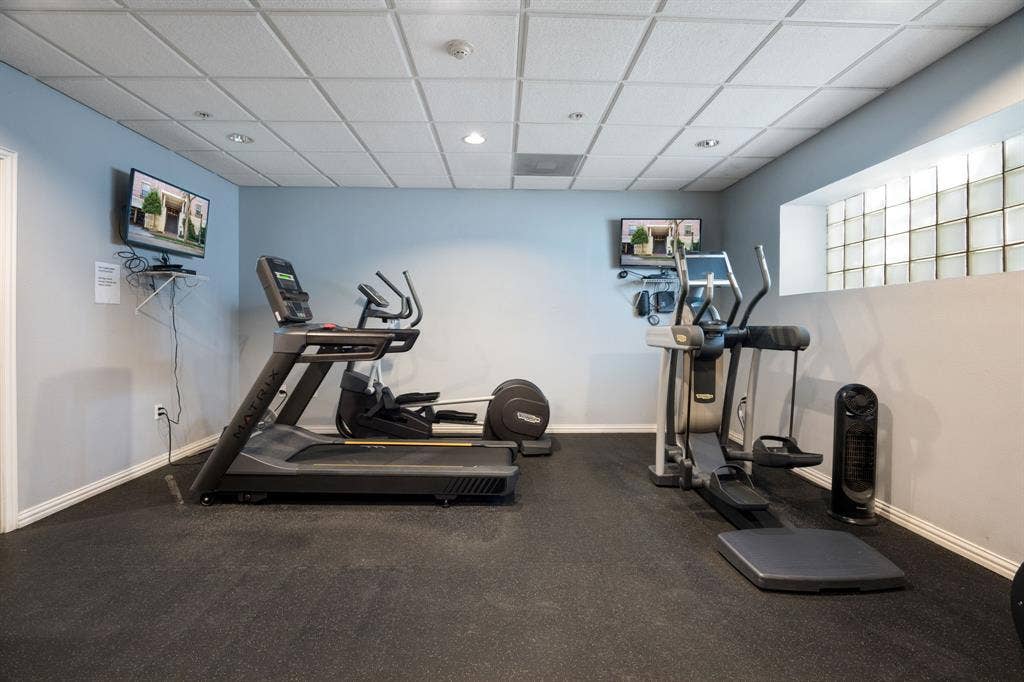2305 Worthington Street, #103, Dallas, TX 75204 Fitness area featuring textured rubber flooring, a drop-tile ceiling with recessed lighting, and a glass block window