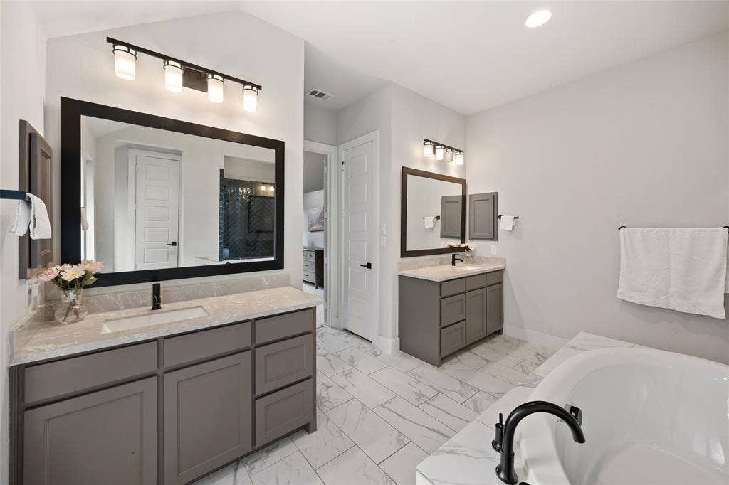 2820 Eccleston Street, Celina, TX 75009 Dual vanities featuring quartz countertops, undermount sinks, matte black fixtures, and custom cabinetry with framed mirrors