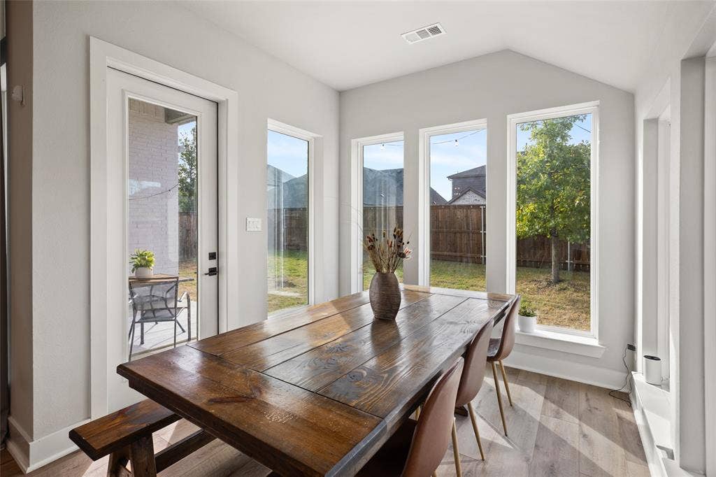 2820 Eccleston Street, Celina, TX 75009 Sunroom featuring high vaulted ceilings, expansive floor-to-ceiling windows, wood-finish flooring, and a glass-paneled exterior door