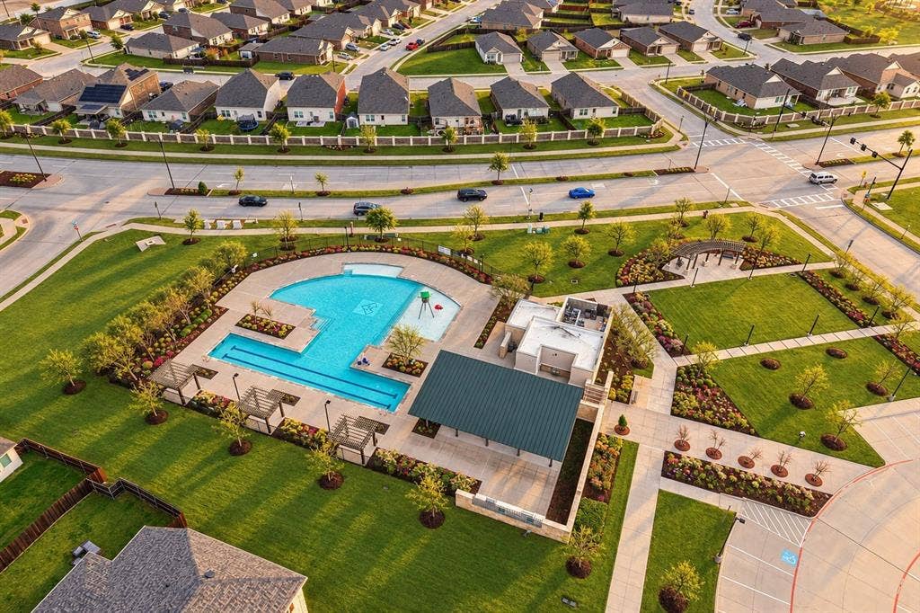 Community recreation area featuring a swimming pool, splash pad, covered pavilion, pergolas, and landscaped green space