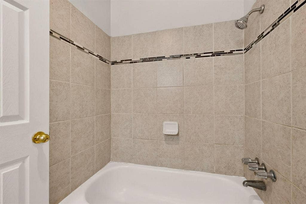 501 Starling Drive, Mesquite, TX 75149 A bright bathroom with an alcove tub against light-colored walls, creating a serene atmosphere.