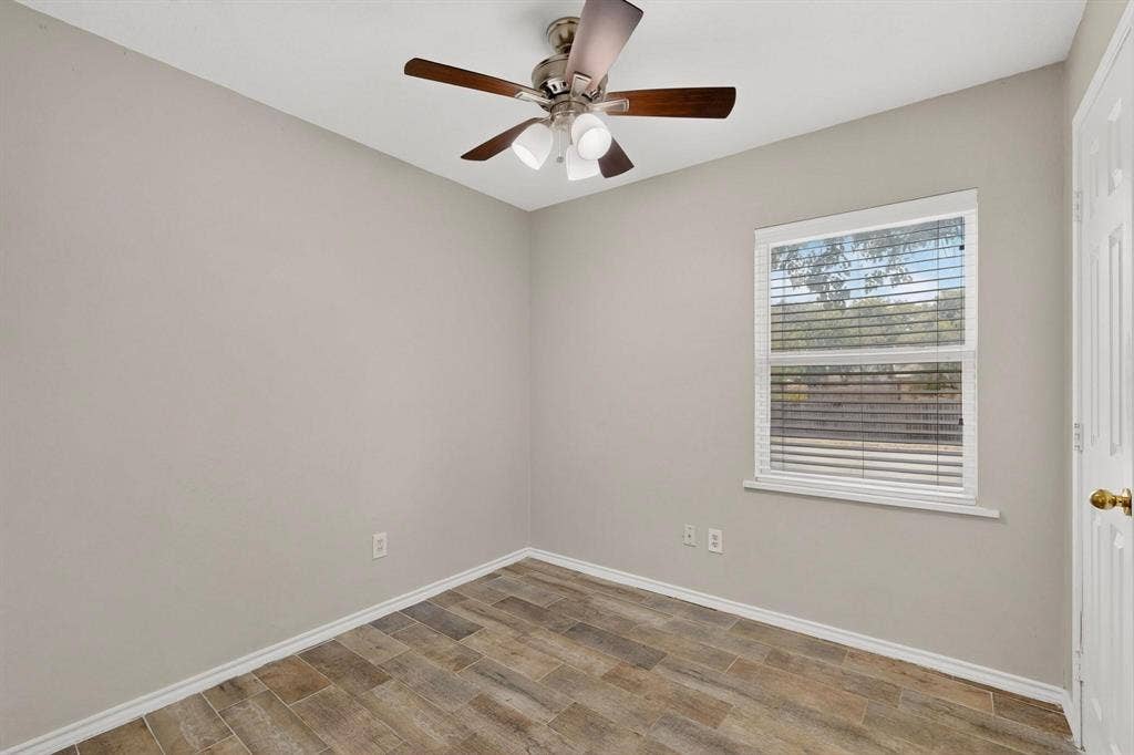 501 Starling Drive, Mesquite, TX 75149 A cozy second bedroom featuring a ceiling fan and a window letting in natural light.