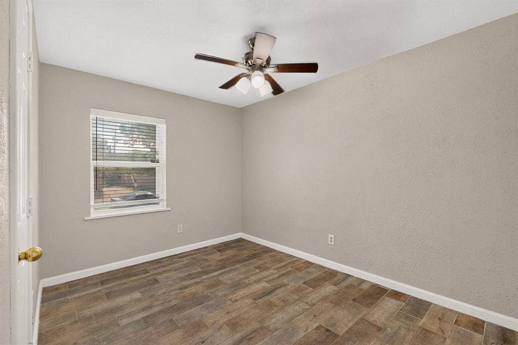 501 Starling Drive, Mesquite, TX 75149 A well-lit third bedroom with a ceiling fan and a window providing a view outside.