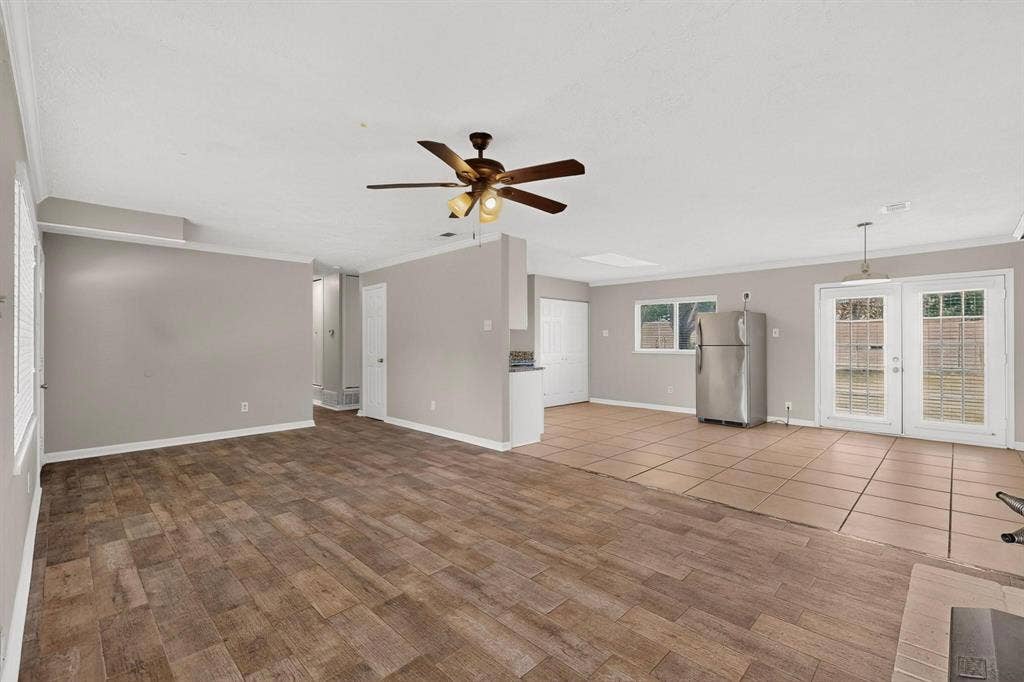 501 Starling Drive, Mesquite, TX 75149 A bright living room featuring hardwood floors and a ceiling fan, ready for new furnishings and decor.