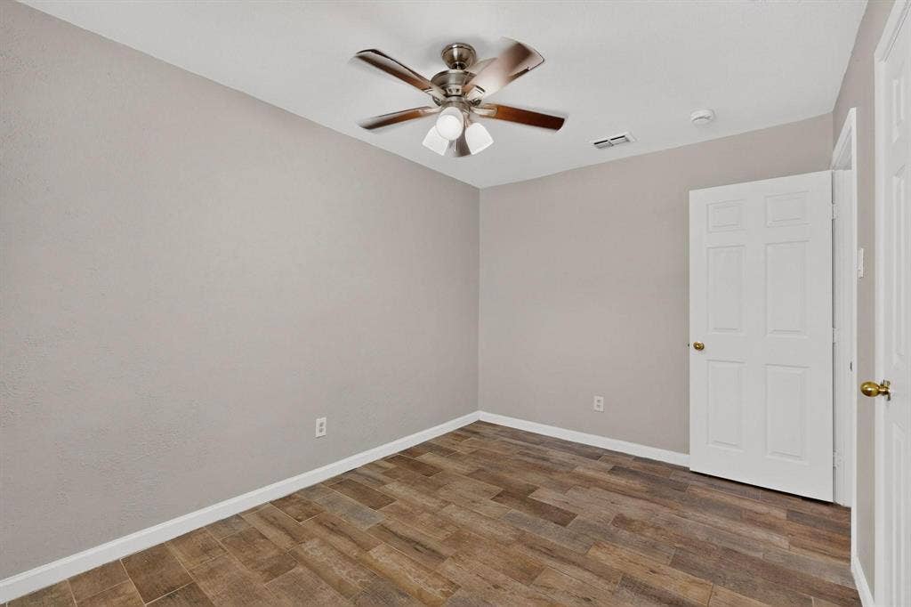 501 Starling Drive, Mesquite, TX 75149 A cozy third bedroom with a ceiling fan, closet and hardwood floors.