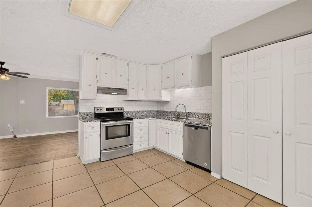 501 Starling Drive, Mesquite, TX 75149 Bright kitchen with sleek white cabinets, stainless steel appliances and tile flooring, designed for functionality and style.