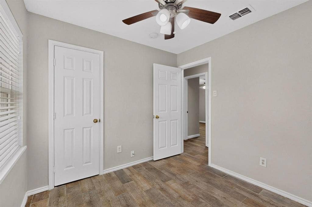 501 Starling Drive, Mesquite, TX 75149 A cozy second bedroom featuring a ceiling fan, closet and a window letting in natural light.