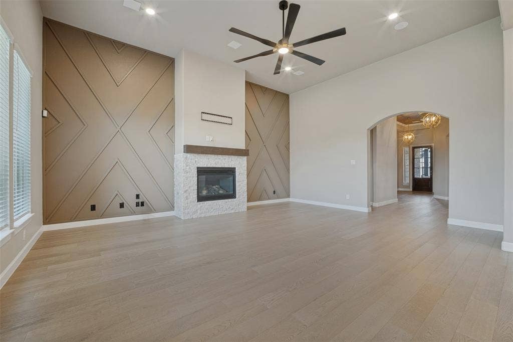 The living room features the same beautiful wood-look flooring, accent walls bookending a cozy fireplace