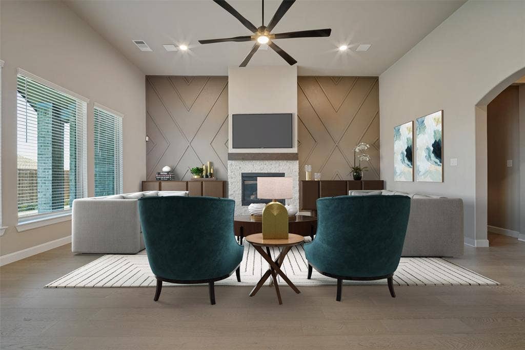 The living room features the same beautiful wood-look flooring, accent walls bookending a cozy fireplace, and flooded in natural light; Virtually staged
