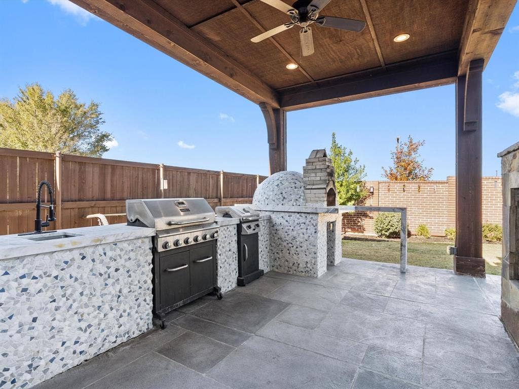 1506 Hennessey Drive, Allen, TX 75013 This covered patio/terrace is the ultimate outdoor entertaining space, thanks to its show-stopping outdoor kitchen. The crowning glory is a professional brick pizza oven, perfect for whipping up delicious pizzas that will impress family and friends alike.