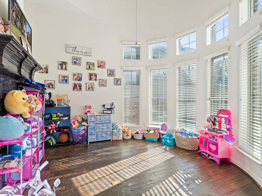1506 Hennessey Drive, Allen, TX 75013 Recreation room with healthy amount of natural light, hardwood / wood-style flooring, and a towering ceiling