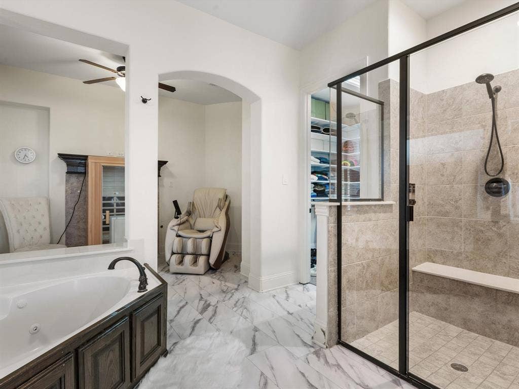 1506 Hennessey Drive, Allen, TX 75013 Bathroom with a shower stall, a walk in closet, a jetted tub, light marble finish floors, and a ceiling fan