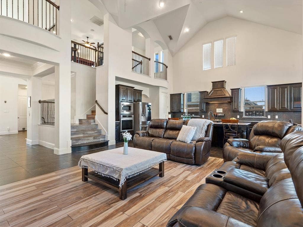 1506 Hennessey Drive, Allen, TX 75013 Living room with a ceiling fan, high vaulted ceiling, wood finish floors, recessed lighting, and stairway
