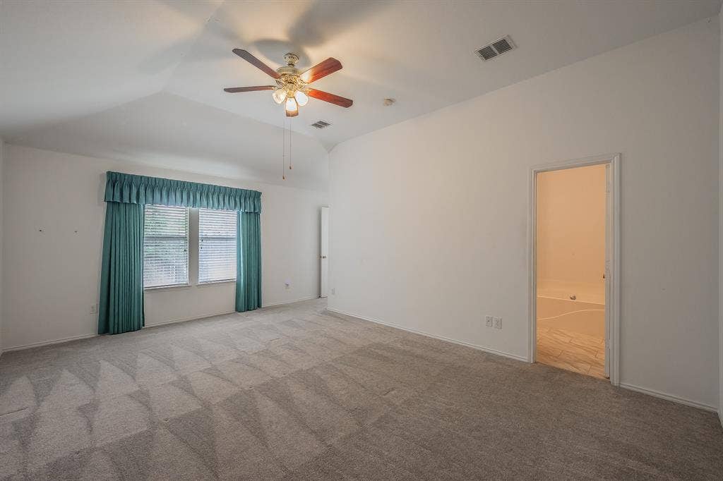 6833 Bluff View Drive, Watauga, TX 76137 Vaulted ceilings, carpeted flooring, and a multi-blade ceiling fan with integrated light fixture