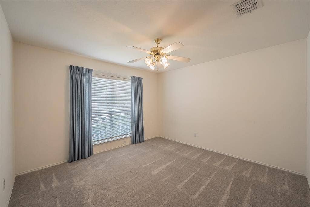 6833 Bluff View Drive, Watauga, TX 76137 Neutral wall palette featuring carpeting, a multi-blade ceiling fan with integrated lighting, and a window with horizontal blinds