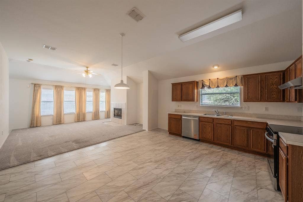 6833 Bluff View Drive, Watauga, TX 76137 Kitchen featuring wood cabinetry, stainless steel appliances, and solid surface countertops