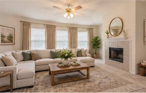 6833 Bluff View Drive, Watauga, TX 76137 Living area featuring a tile-surround fireplace with a mantel, vaulted ceilings, multi-panel window configuration, and a ceiling fan with integrated lighting