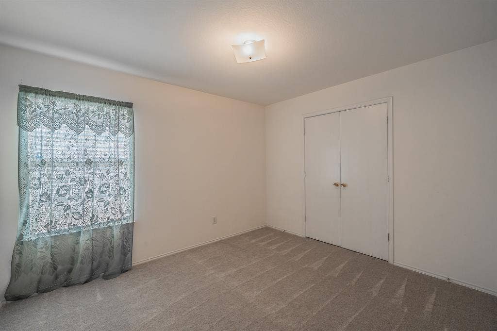 6833 Bluff View Drive, Watauga, TX 76137 Neutral interior room featuring wall-to-wall carpeting, dual-door reach-in closet, and flush-mount ceiling lighting