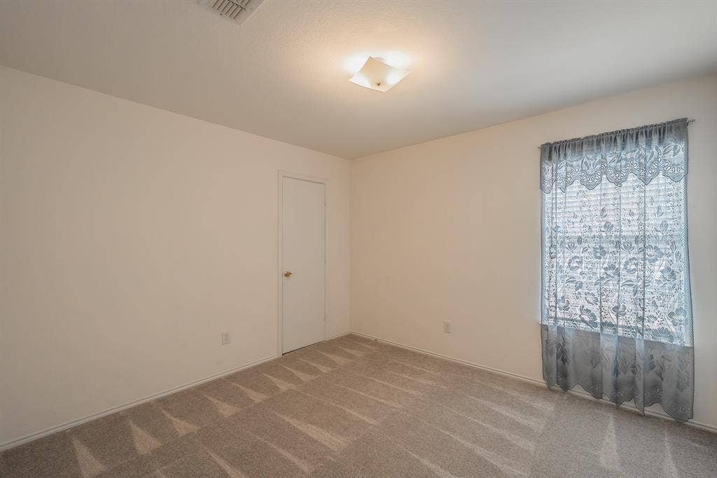 6833 Bluff View Drive, Watauga, TX 76137 Interior space featuring neutral wall tones, wall-to-wall carpeting, a single-panel interior door, and a flush-mount light fixture