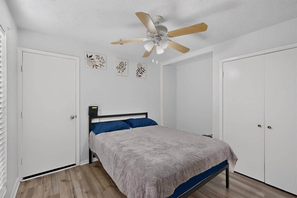 2228 Bunker Hill Drive, Carrollton, TX 75006 Room featuring wood-finish flooring, a ceiling fan with integrated lighting, a recessed alcove, and a double-door closet