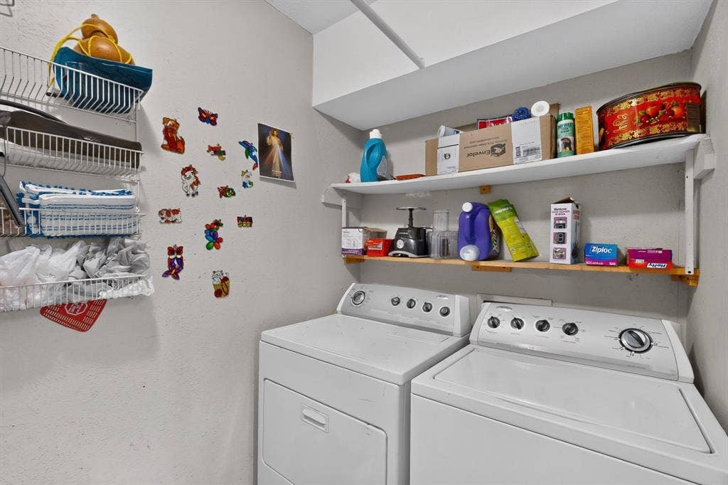 2228 Bunker Hill Drive, Carrollton, TX 75006 Utility space featuring wall-mounted wire shelving, open fixed-mount wooden shelving, and overhead storage cabinetry