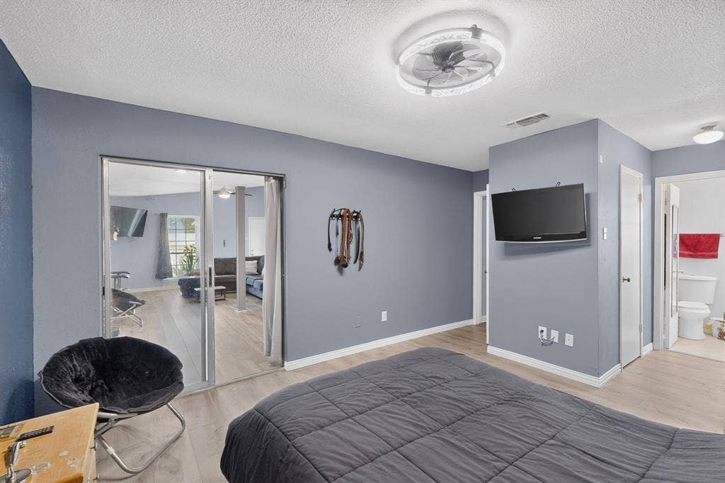2228 Bunker Hill Drive, Carrollton, TX 75006 Neutral wall tones, wood-finish flooring, recessed lighting, and a modern circular ceiling fan with integrated illumination