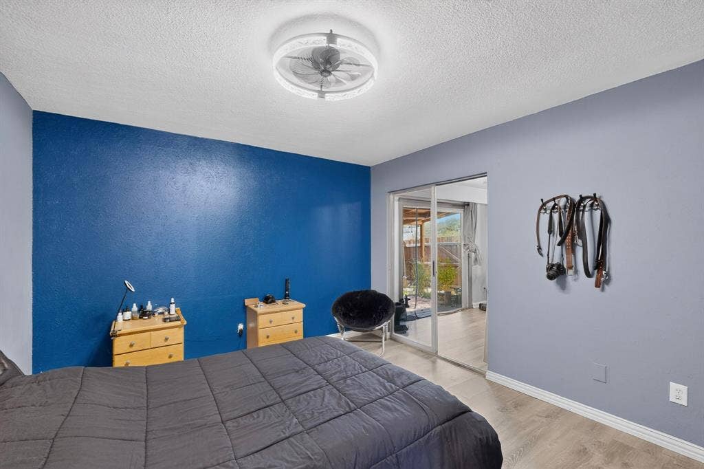 2228 Bunker Hill Drive, Carrollton, TX 75006 Room featuring wood-finish flooring, sliding glass door, and a circular ceiling fan with integrated lighting