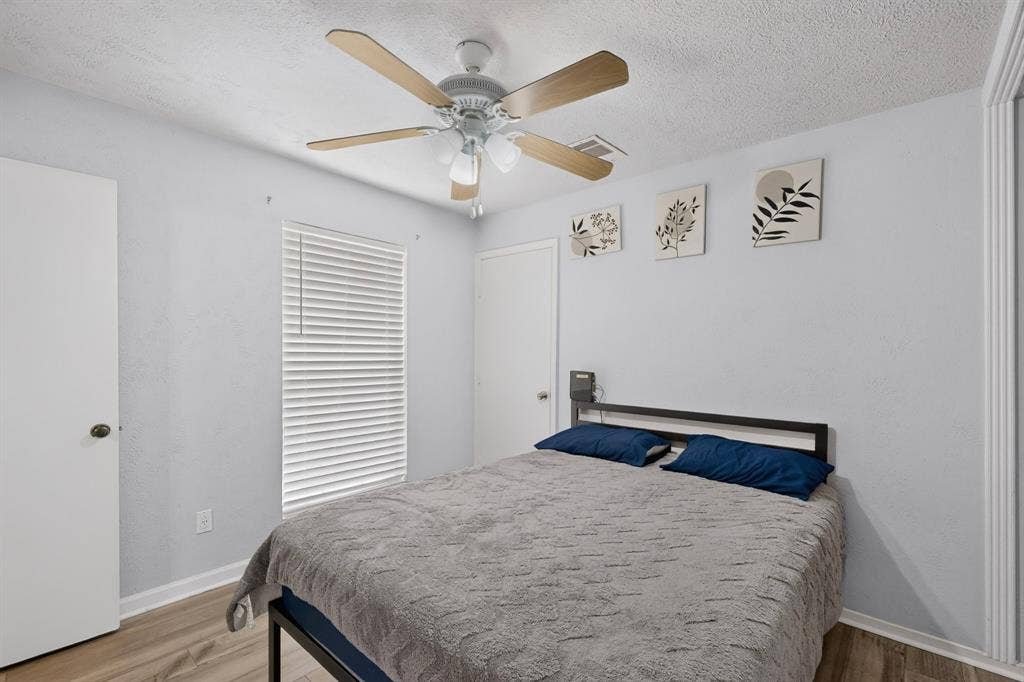 2228 Bunker Hill Drive, Carrollton, TX 75006 Wood-finish flooring, ceiling fan with integrated lighting, and horizontal window blinds