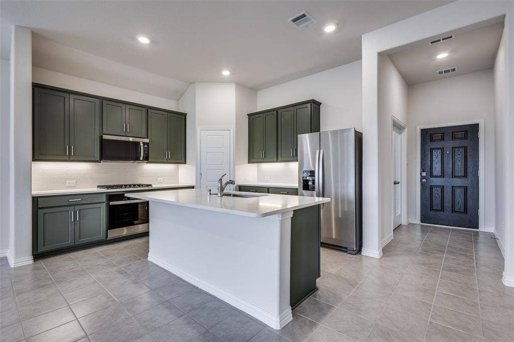 3325 Cross Shore Drive, Anna, TX 75409 Kitchen featuring a sink, visible vents, light countertops, appliances with stainless steel finishes, and decorative backsplash