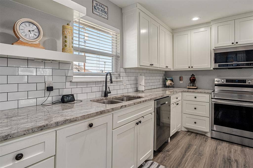 519 MAE Drive, Mabank, TX 75147 Kitchen featuring white shaker-style cabinetry, stone countertops, a subway tile backsplash, stainless steel appliances, and wood-finish flooring