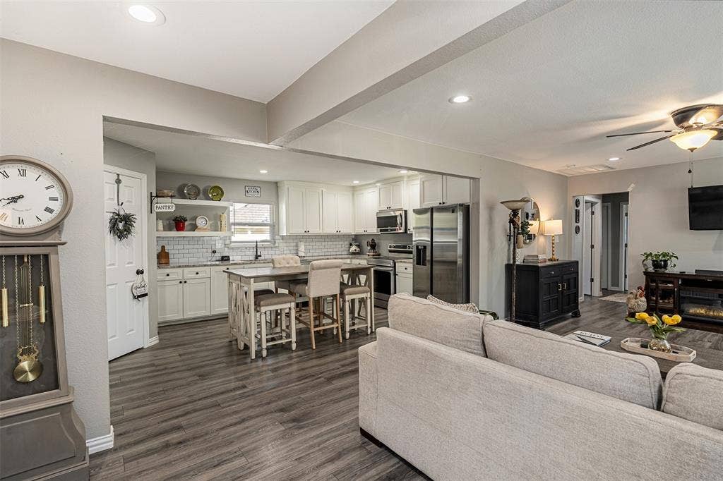519 MAE Drive, Mabank, TX 75147 Kitchen featuring white cabinetry, subway tile backsplash, stainless steel appliances, and a central island, with wood-finish flooring throughout the space