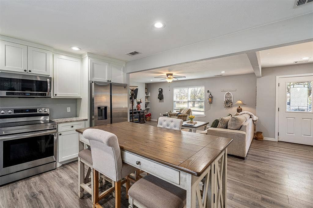 519 MAE Drive, Mabank, TX 75147 Kitchen featuring white shaker-style cabinetry, stainless steel appliances, and wood-finish flooring throughout the space