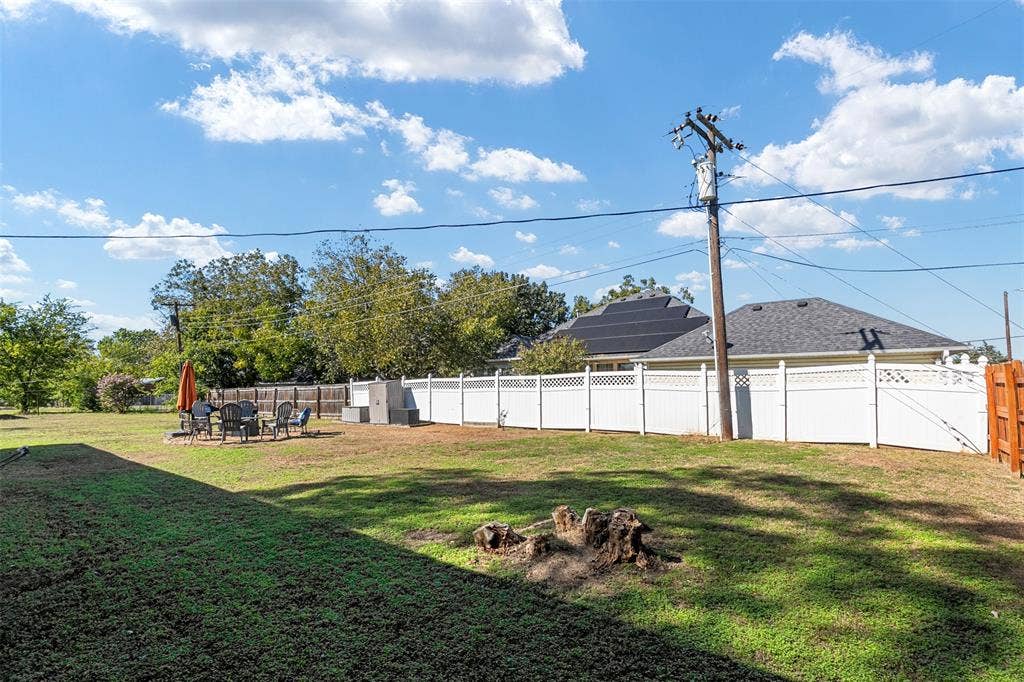 519 MAE Drive, Mabank, TX 75147 Expansive backyard featuring a white lattice-top vinyl privacy fence and roof-mounted solar panels