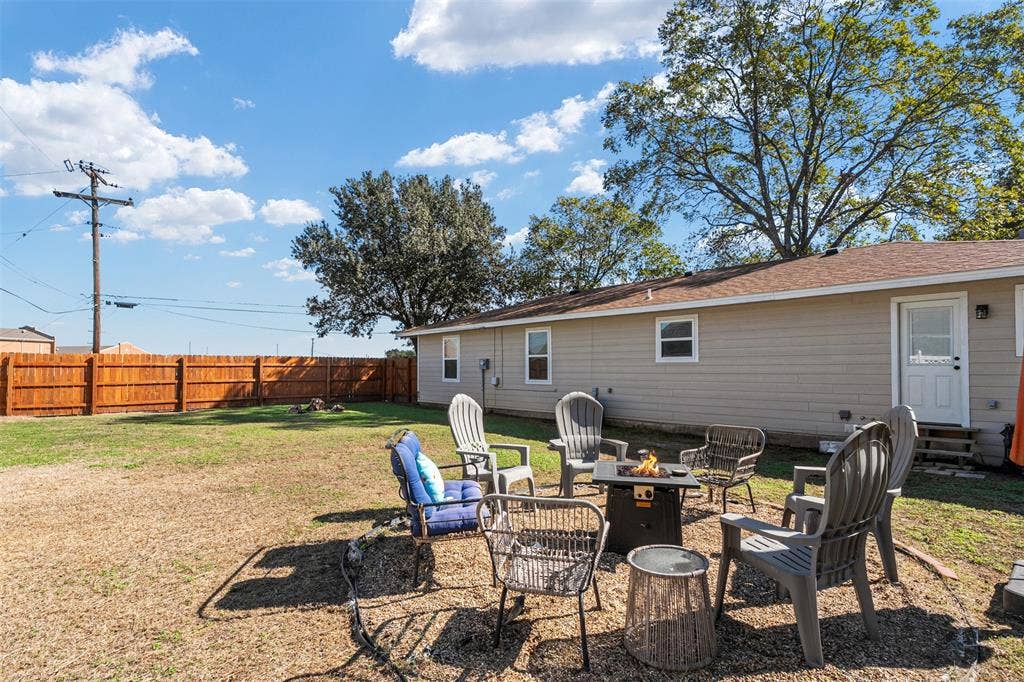 519 MAE Drive, Mabank, TX 75147 Backyard featuring a wood privacy fence, exterior siding, and a designated gravel fire pit area