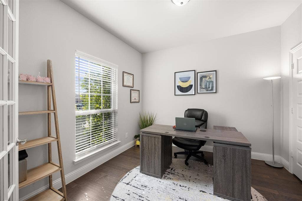 Multi-purpose room featuring wood-finish flooring, a glass-panel French door, and a single-hung window with blinds
