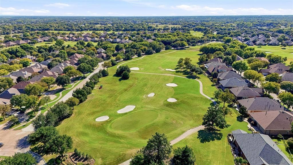 819 Mustang Drive, Fairview, TX 75069 Aerial perspective of a golf course featuring manicured greens, sand bunkers, paved cart paths, and mature landscaping
