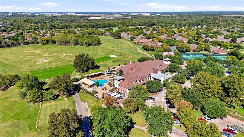 819 Mustang Drive, Fairview, TX 75069 Aerial view featuring an expansive clubhouse, outdoor swimming pool, tennis courts, and bordering golf course greens