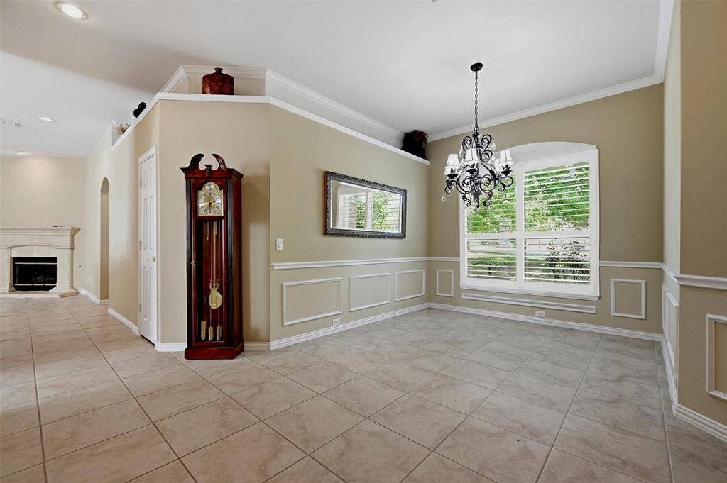 819 Mustang Drive, Fairview, TX 75069 Dining area featuring tile flooring, decorative wall molding, a multi-arm chandelier, and plantation shutters