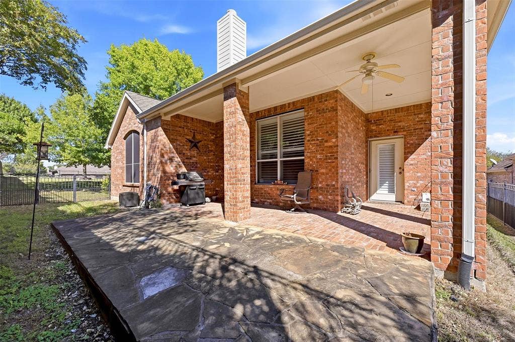 819 Mustang Drive, Fairview, TX 75069 Covered brick patio featuring stone pavers, a ceiling fan, and a exterior brick chimney